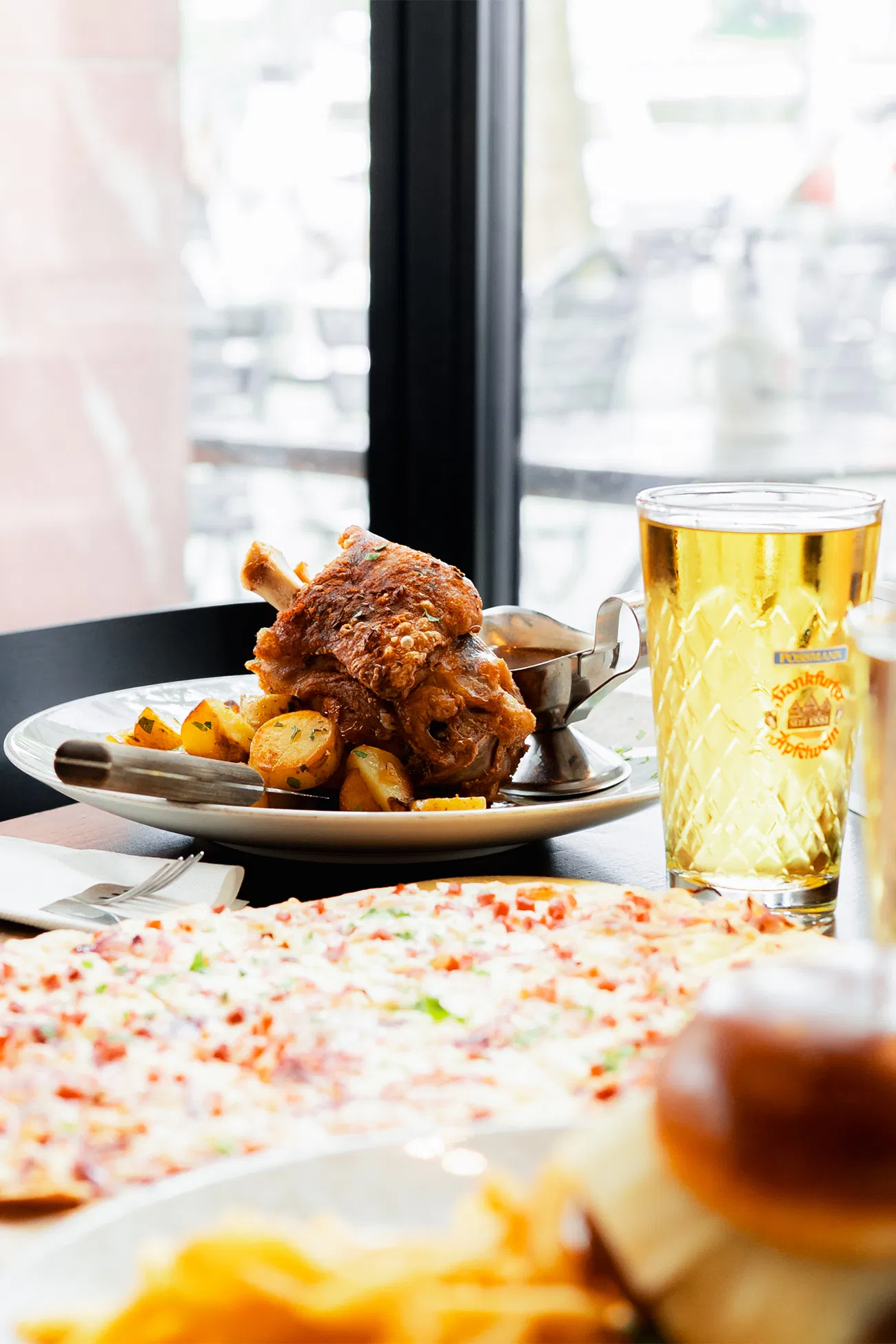Schweinshaxe und Bier am Fenstertisch im Frankfurter Wirtshaus